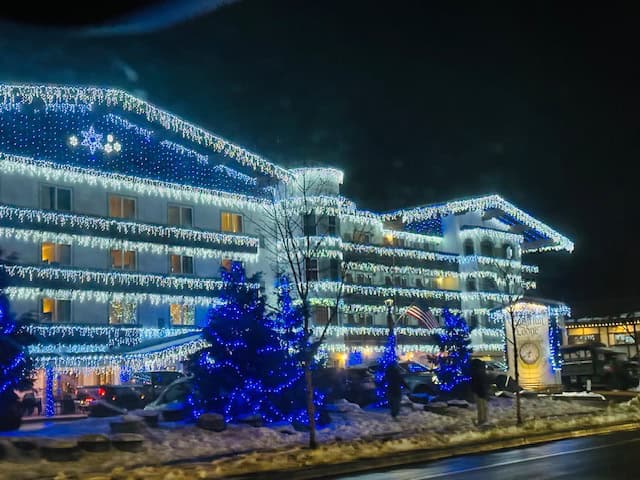 Bavarian Lodge in Leavenworth, Washington glowing with blue and white Christmas lights on a snowy winter night