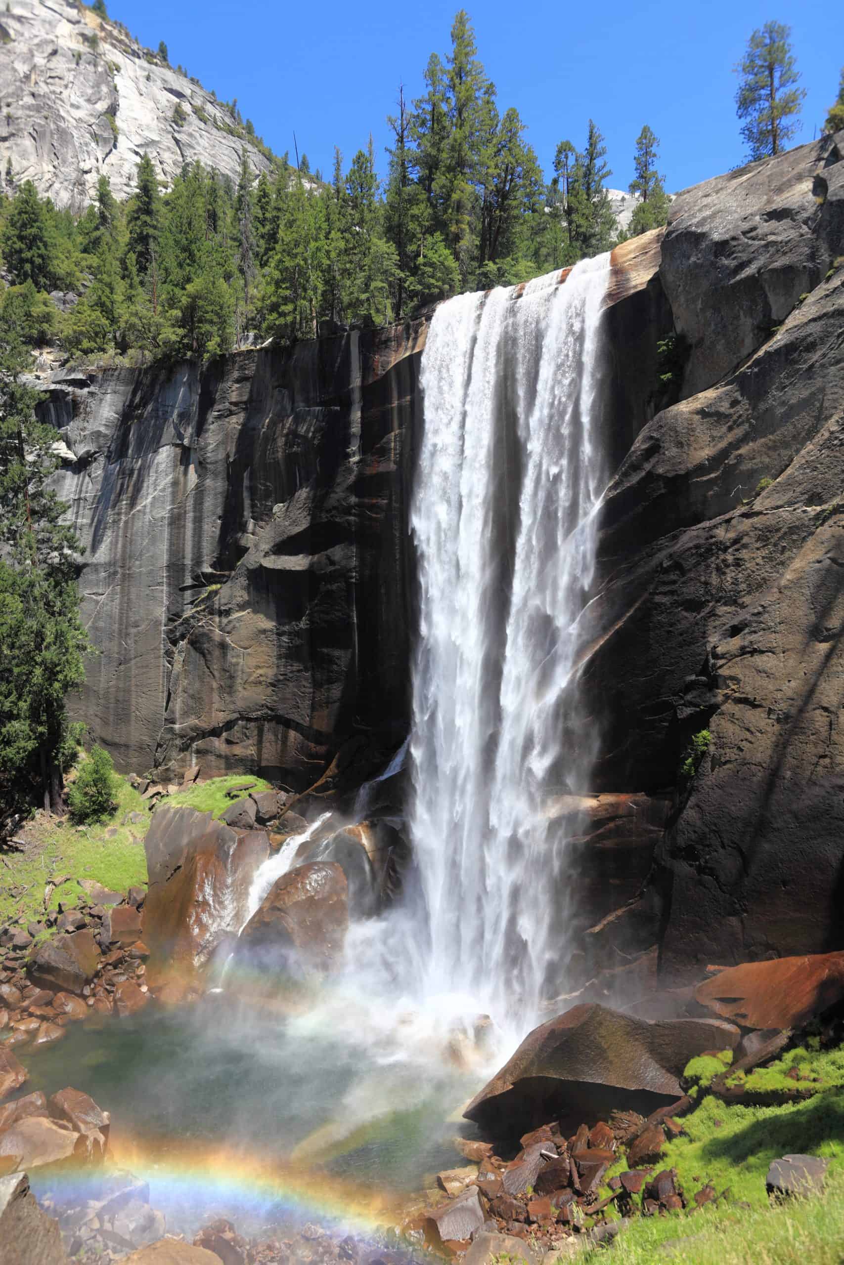 Vernal Fall cascading into an emerald pool with a rainbow in Yosemite National Park