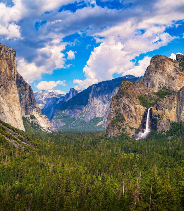 Scenic view of Yosemite Valley with Bridalveil Fall, El Capitan, and Half Dome under a dramatic sky in Yosemite National Park