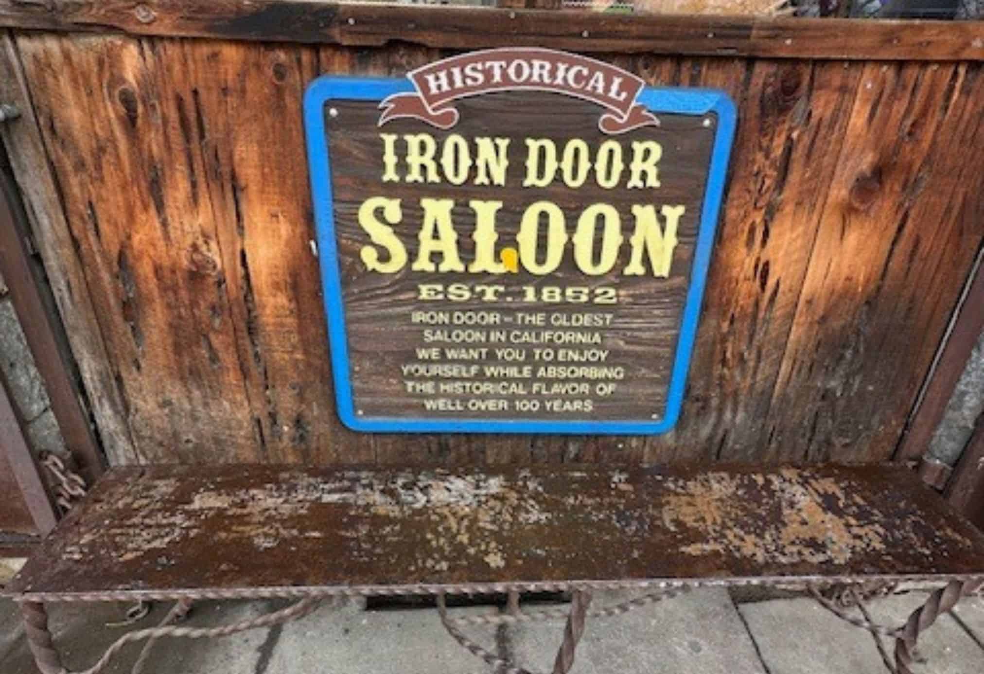 Historic Iron Door Saloon in Groveland, California — the oldest saloon in California, established in 1852, featuring a weathered wooden sign and rustic charm