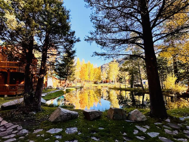Rons Pond at the Double Eagle Resort and Spa reflecting fall colors and mountain cabins in June Lake