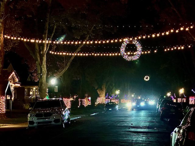 Fab 40s neighborhood in Sacramento decorated with Christmas lights, glowing wreaths, and festive homes along a tree-lined street at night
