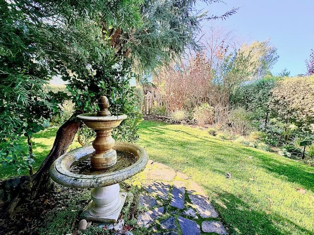 Garden fountain surrounded by greenery at Cambria Pines Lodge, with walking paths and landscaped grounds on California’s Central Coast