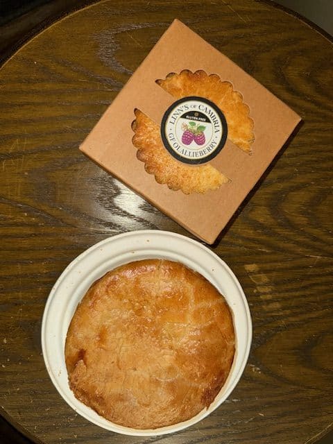 A savory chicken pot pie and a boxed olallieberry pie from Linn's Restaurant displayed on a wooden table in Cambria