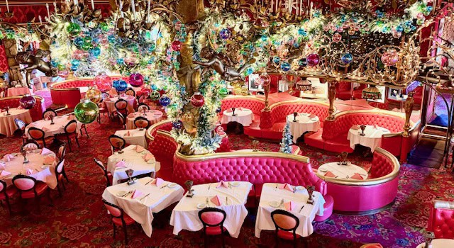 Colorful interior of the Madonna Inn restaurant near Cambria, California, featuring ornate decor, pink booths, chandeliers, and whimsical details