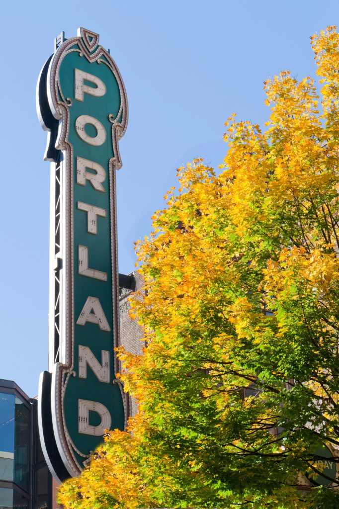 Portland Oregon sign with bright fall foliage in downtown Portland on a clear day