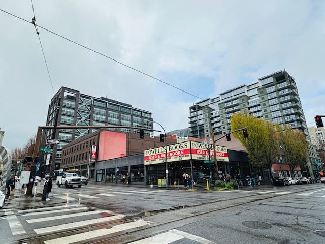 Exterior view of Powell’s City of Books in downtown Portland, Oregon on a rainy day with city streets and modern buildings in the background