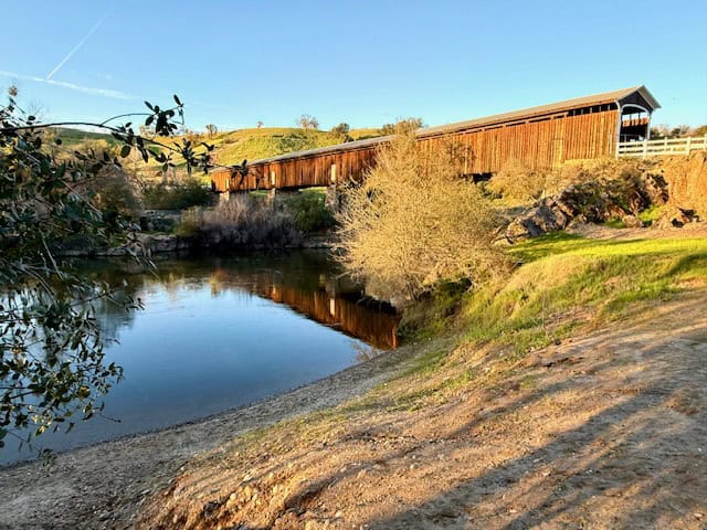 Knights Ferry Covered Bridge reflecting on the Stanislaus River in Knights Ferry California