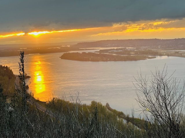 Golden sunset over the Columbia River near Portland Oregon viewed from a scenic overlook with glowing reflections on the water