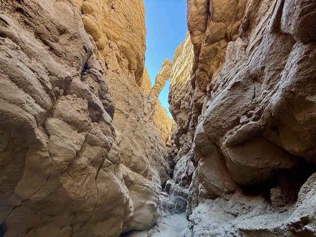 narrow sandstone slot canyon walls with blue sky above in Anza Borrego Desert State Park