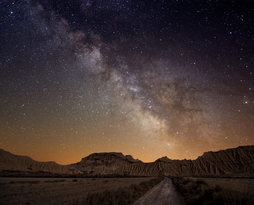 Milky Way over Anza-Borrego Desert State Park with rugged badlands and a dirt road under a star-filled night sky