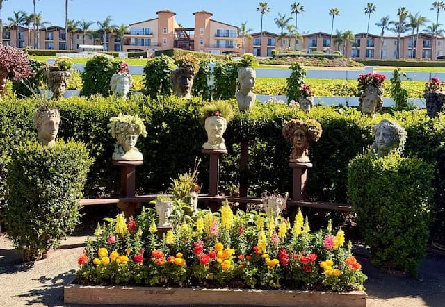 Decorative plant head sculptures display at The Flower Fields in Carlsbad California with colorful flowers and greenery