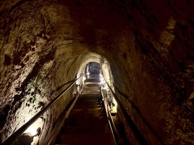 Staircase leading through Sunny Jim’s Cave tunnel in La Jolla California with dramatic rock walls and soft lighting