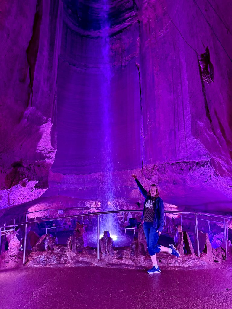 Traveler posing in front of the illuminated underground waterfall at Ruby Falls in Chattanooga, Tennessee, during a Chattanooga 2 Day Itinerary