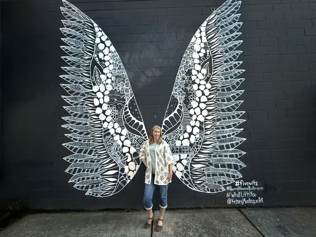 Traveler posing in front of the Angel Wings mural in downtown Chattanooga, Tennessee, a popular photo stop on a Chattanooga 2 Day Itinerary