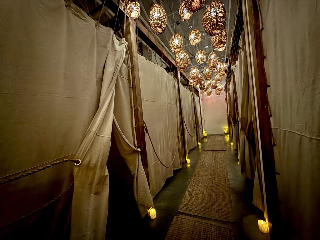 Interior of The NOW Massage in El Dorado Hills with private curtained treatment rooms and woven pendant lights